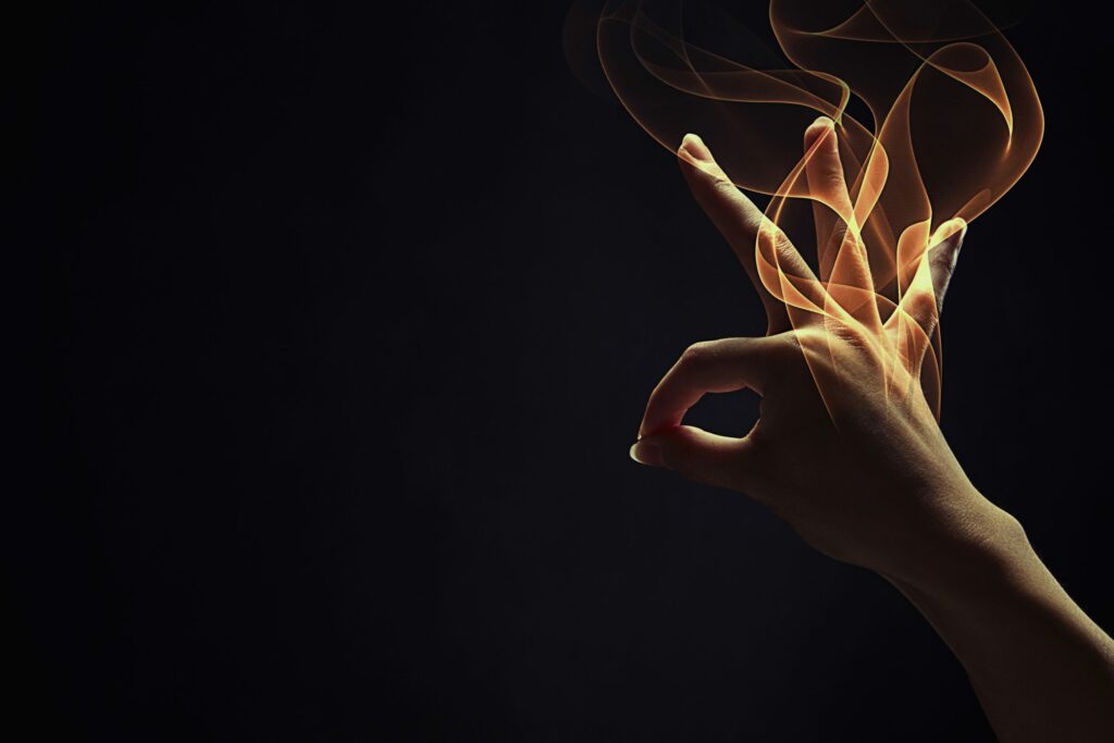 A hand signing against a black background.